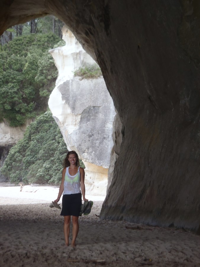 Lindsay reluctantly stops for a picture in the cold tunnel that leads to Cathedral Cove