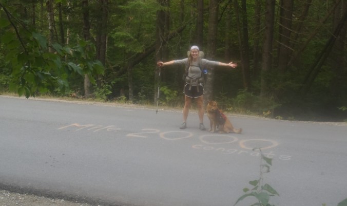 Lindsay at the historic and iconic 2,000mi mark painted on an unknown road in northern Maine